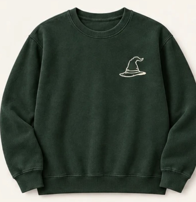 The Seal Crewneck in Forest Green, front — small hat mark over the heart