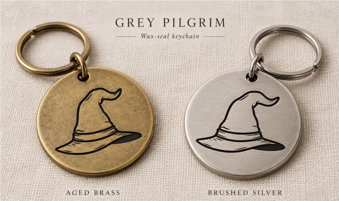 Wax-seal keychains — the hat mark engraved on round tags in aged brass and brushed silver
